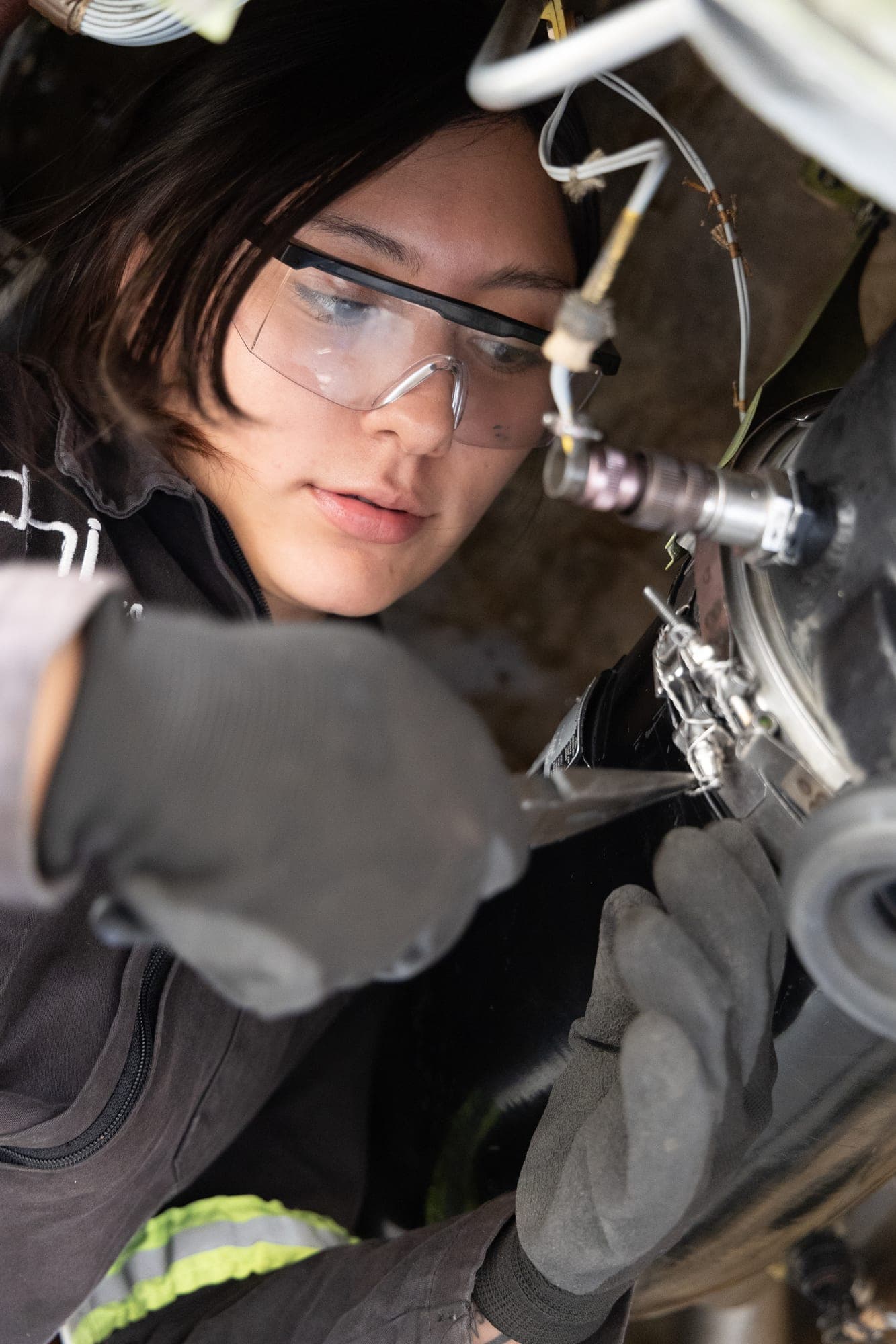 Técnica con gafas de protección trabajando en componentes aeronáuticos